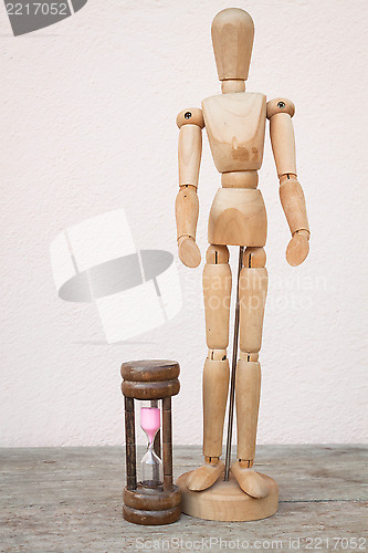 Image of Wood mannequin and hourglass to represent spending time