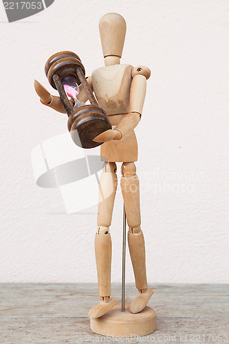 Image of Wood mannequin and hourglass to represent time caring 