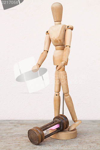 Image of Wood mannequin and hourglass to represent unfortunately time