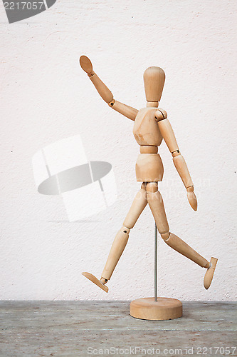 Image of Wooden figure pose as happy jumping forward