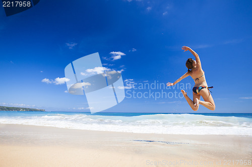 Image of Woman jumping on the beach