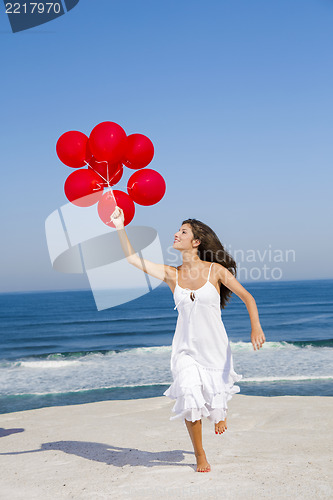 Image of Beautiful girl running with red ballons