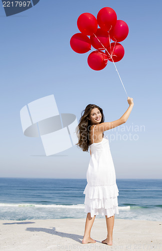 Image of Beautiful girl holding red ballons