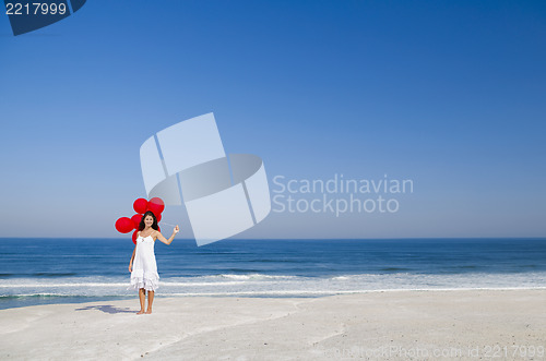 Image of Beautiful girl holding red ballons