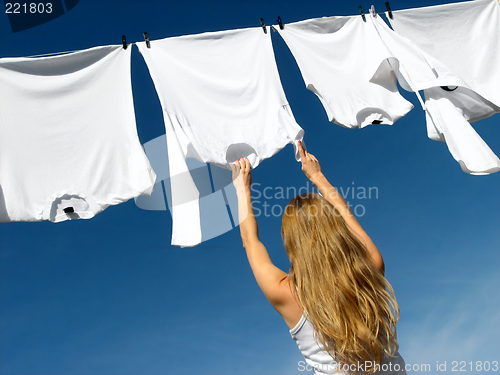 Image of Longhaired girl, blue sky and white laundry