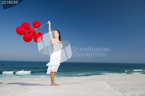 Image of Beautiful girl holding red ballons
