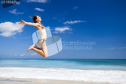 Image of Woman jumping on the beach
