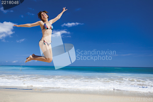 Image of Woman jumping on the beach