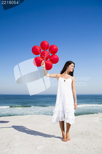 Image of Beautiful girl holding red ballons