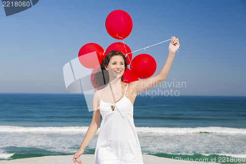 Image of Beautiful girl holding red ballons