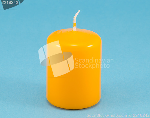 Image of yellow thick wax candle wick blue background 