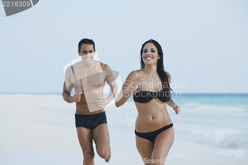 Image of Couple running on the beach