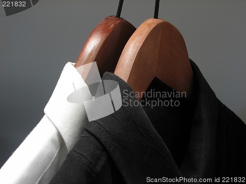 Image of Black and white shirts on wooden hangers