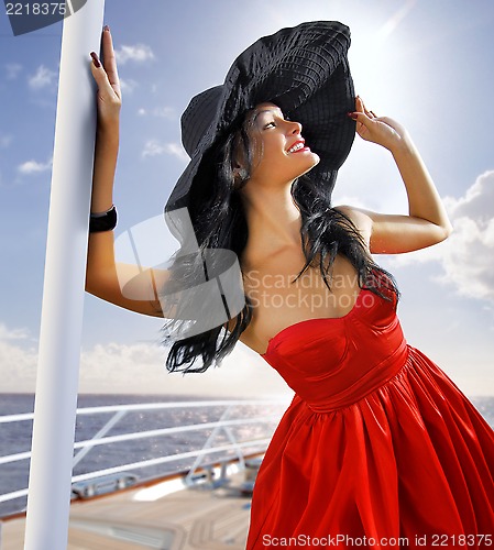 Image of beautiful woman in red dress on the yacht
