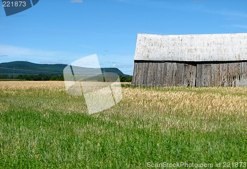 Image of Mountains and old wooden barn in the field