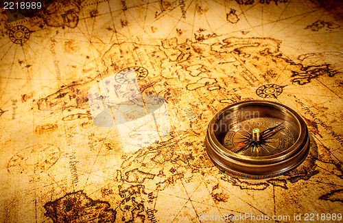 Image of Vintage compass lies on an ancient world map.