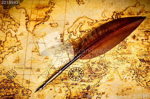 Image of Vintage goose quill pen lying on an old map.