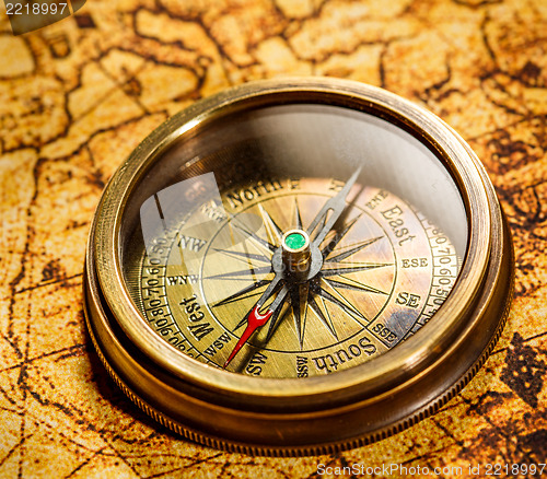 Image of Vintage compass lies on an ancient world map.