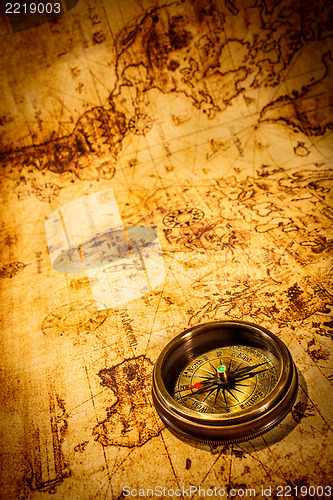 Image of Vintage compass lies on an ancient world map.