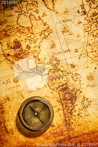 Image of Vintage compass lies on an ancient world map.