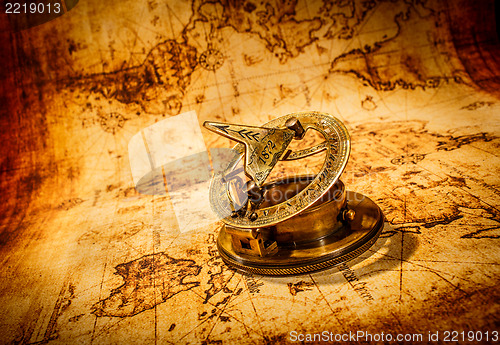 Image of Vintage compass lies on an ancient world map.