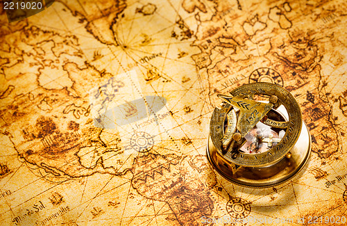 Image of Vintage compass lies on an ancient world map.