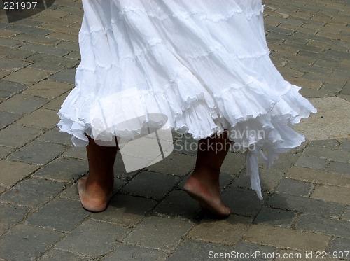 Image of Woman in a white dress dancing to Brazilian rhythms