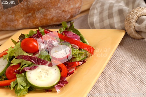 Image of Crisp salad on a yellow plate with rustic bread