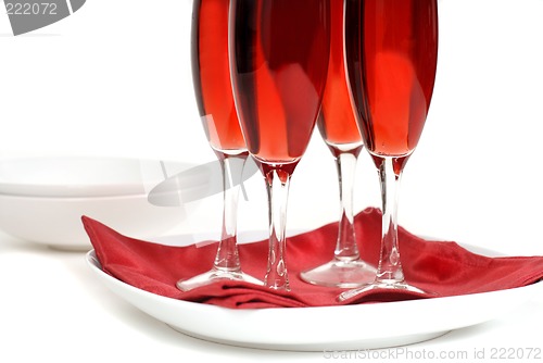 Image of Four glasses of rose champagne on a red napkin isolated on white