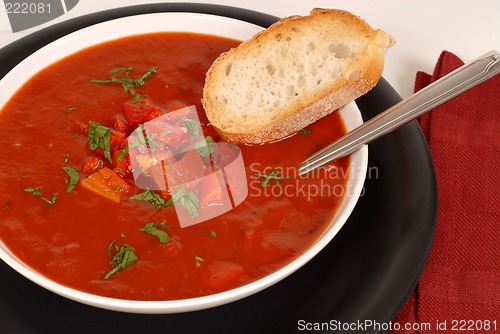 Image of Overhead view of a bowl of tomato, red pepper and basil soup wit