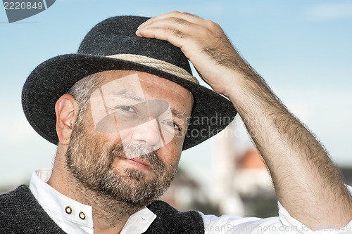 Image of Man holding his Bavarian black hat