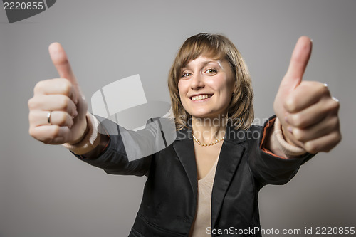 Image of Young business woman with two thumbs held high