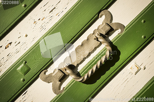 Image of Metal handle on white green gate