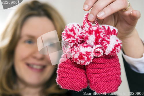 Image of Blond woman with baby shoes