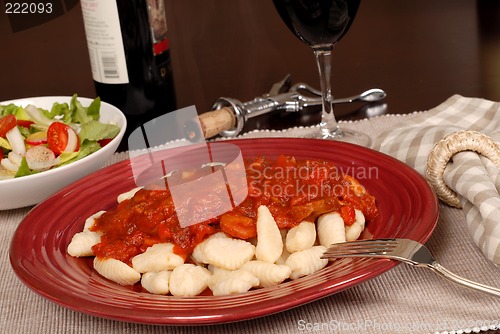 Image of Potato gnocchi with marinara sauce with a salad and wine