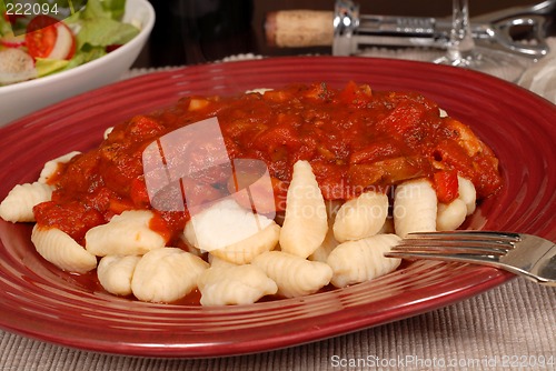 Image of Close up of potato gnocchi with marinara sauce with a salad