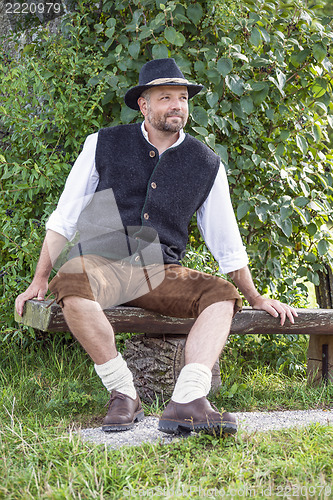 Image of Seated man in traditional Bavarian costumes and black hat