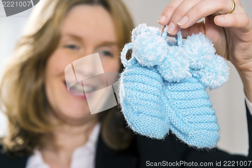 Image of Blond woman with blue baby shoes