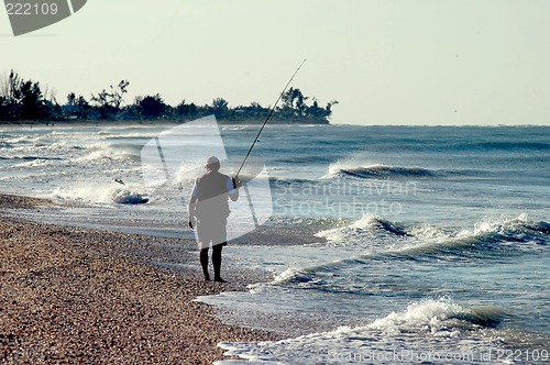 Image of fisherman on sandy beach