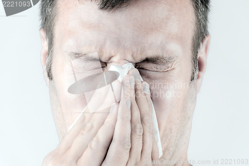 Image of Man with is sneezing