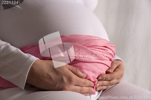 Image of Pregnant woman is holding her baby bump