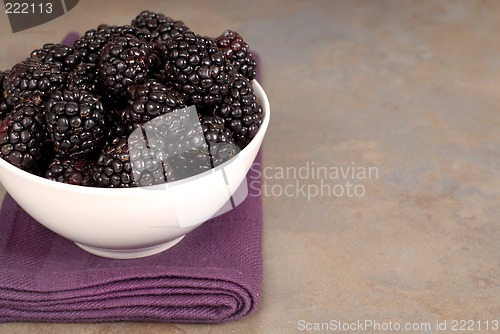 Image of Blackberries in a white bowl on a purple napkin