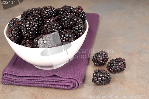 Image of Blackberries in a white bowl on a purple napkin with blackberrie