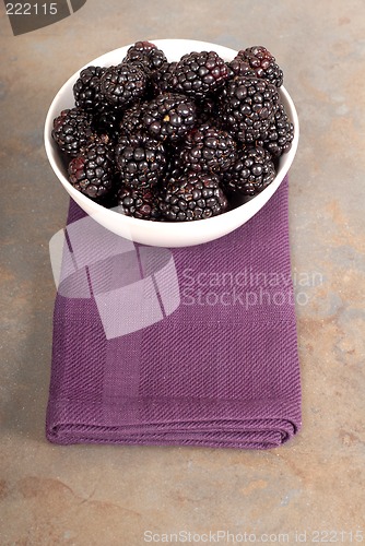 Image of Vertical view of blackberries in a white bowl on a purple napkin