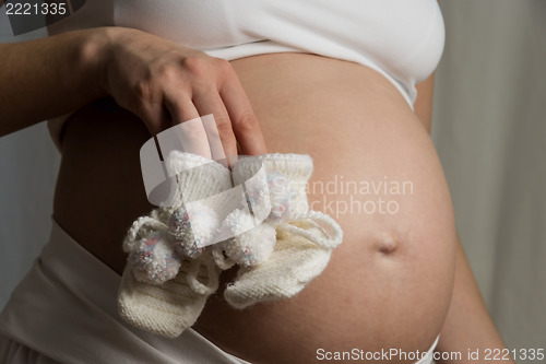 Image of baby bump with baby shoes