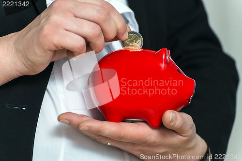 Image of Close up pregnant business womans hands with piggy bank