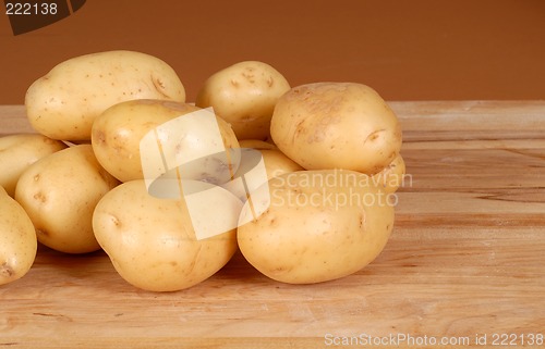 Image of Several white potatoes piled on a cutting board