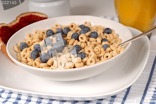 Image of Bowls of oat cereal with blueberries and spoon, toast with raspb