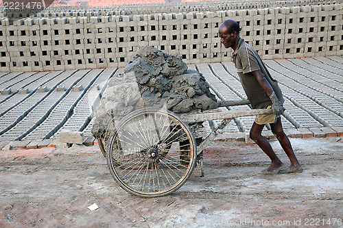 Image of Laborers are carrying soil from the river and keeping them in the brick field area