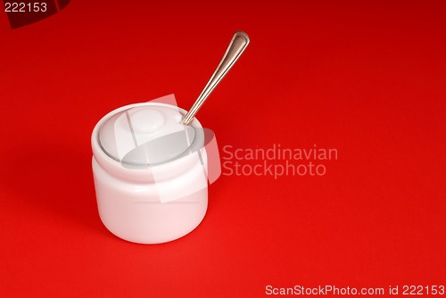 Image of White sugar bowl on a red background